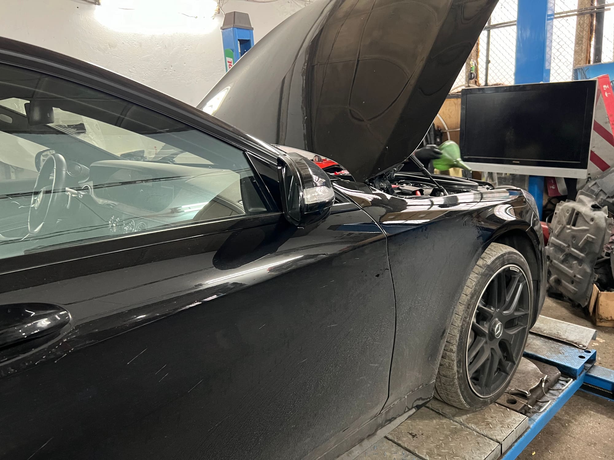 Mercedes с вдигнат капак на подемника в сервиза